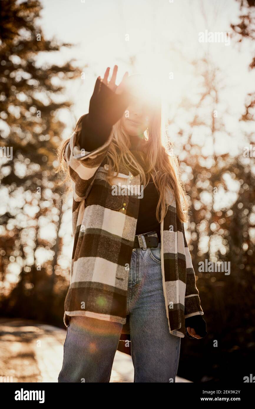 Junge Frau, die während eines sonnigen Tages im Park steht Stockfoto