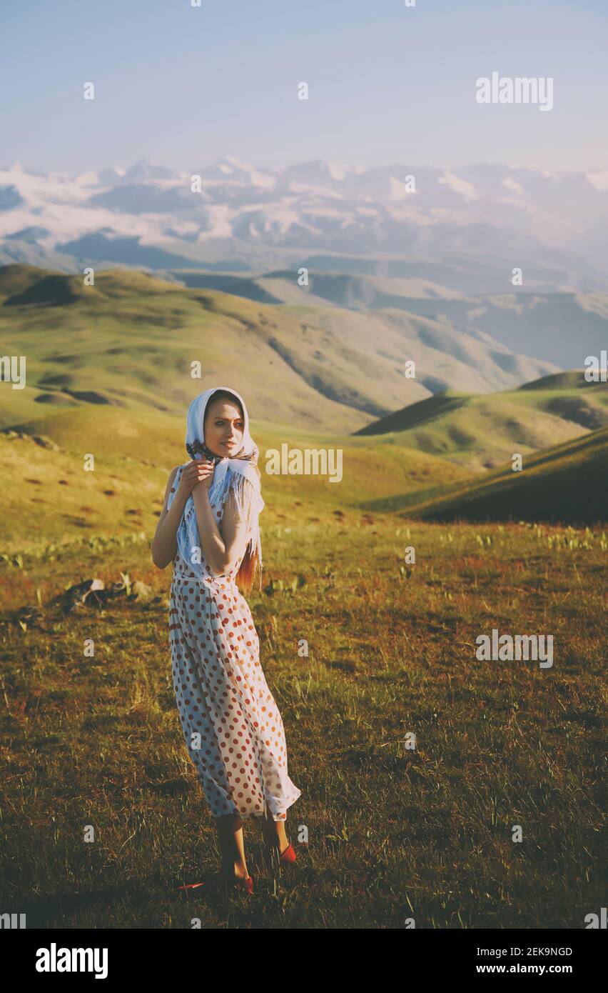 Junge Frau mit Polka-Dot-Kleid, die gegen Berge steht Stockfoto