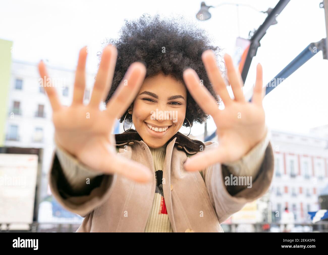 Lächelnde Frau mit Stop-Geste, während sie im Freien steht Stockfoto