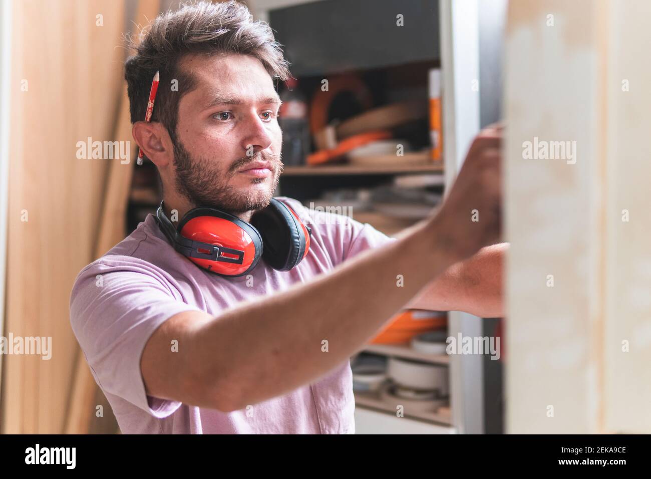 Männlicher Handwerker mit Ohrenschützern in der Werkstatt Stockfoto