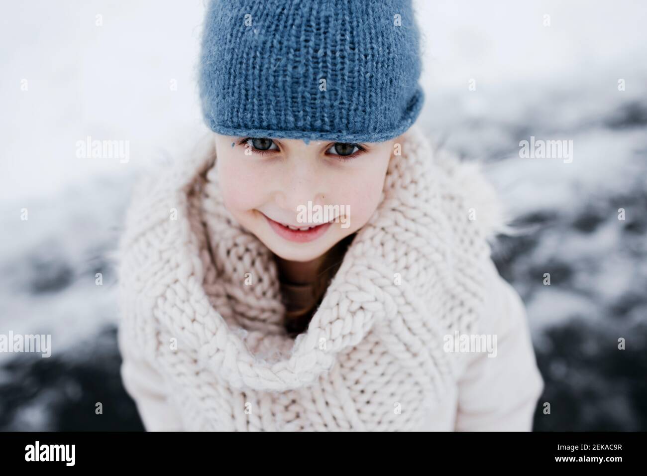 Glückliches kleines Mädchen in warmer Kleidung im Winter Stockfoto