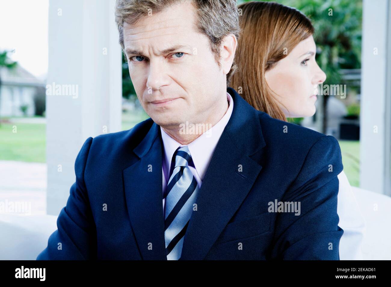 Geschäftsmann und eine Geschäftsfrau, die sich zurück an den Rücken lehnen Stockfoto