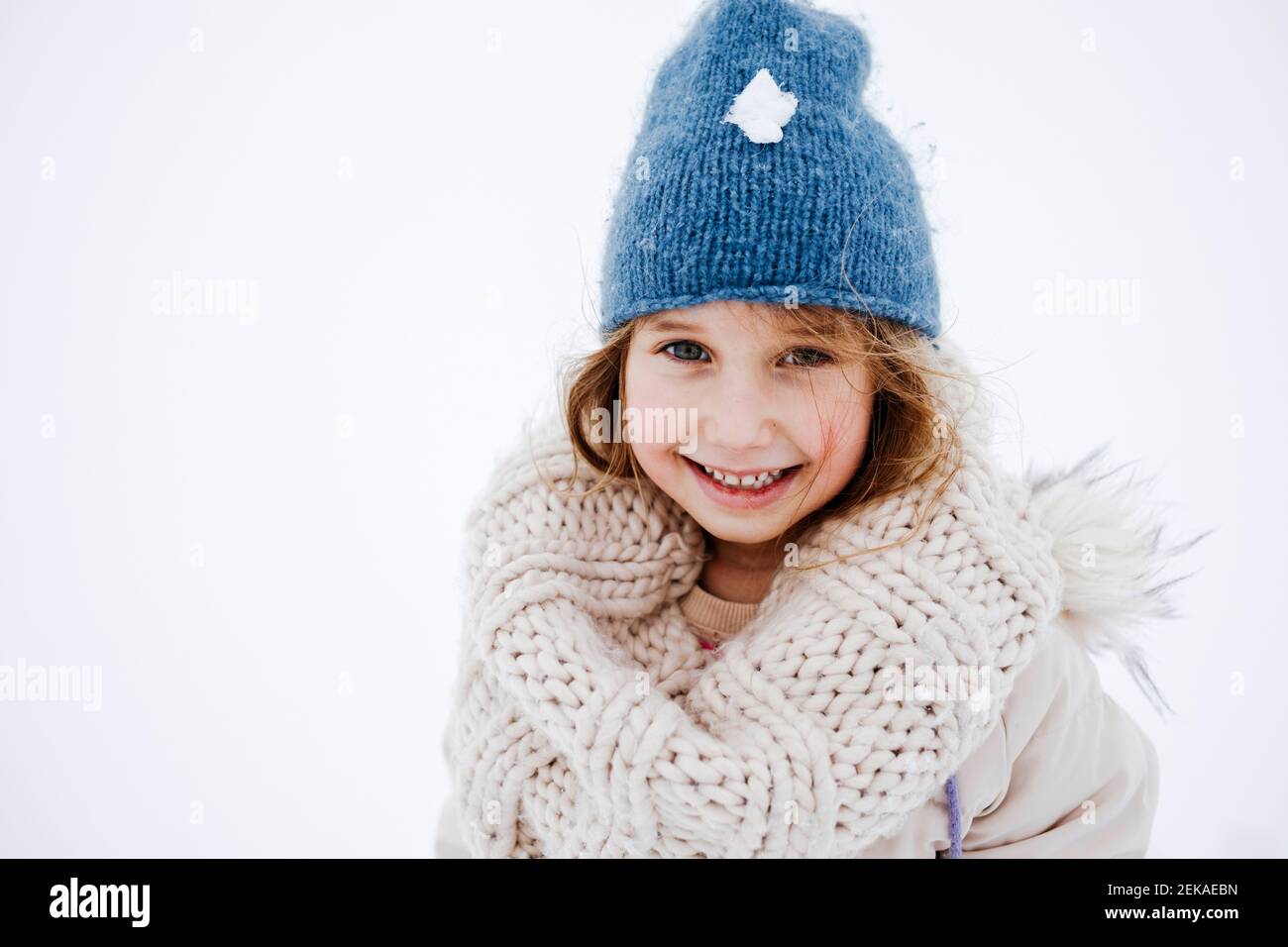 Nettes lächelndes Mädchen in gestrickter warmer Kleidung im Winter Stockfoto