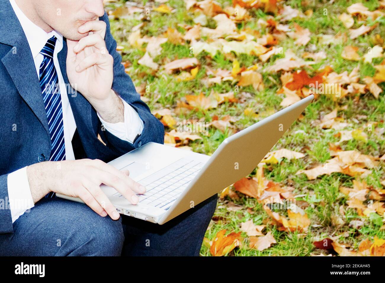 Geschäftsmann mit einem Laptop in einem park Stockfoto