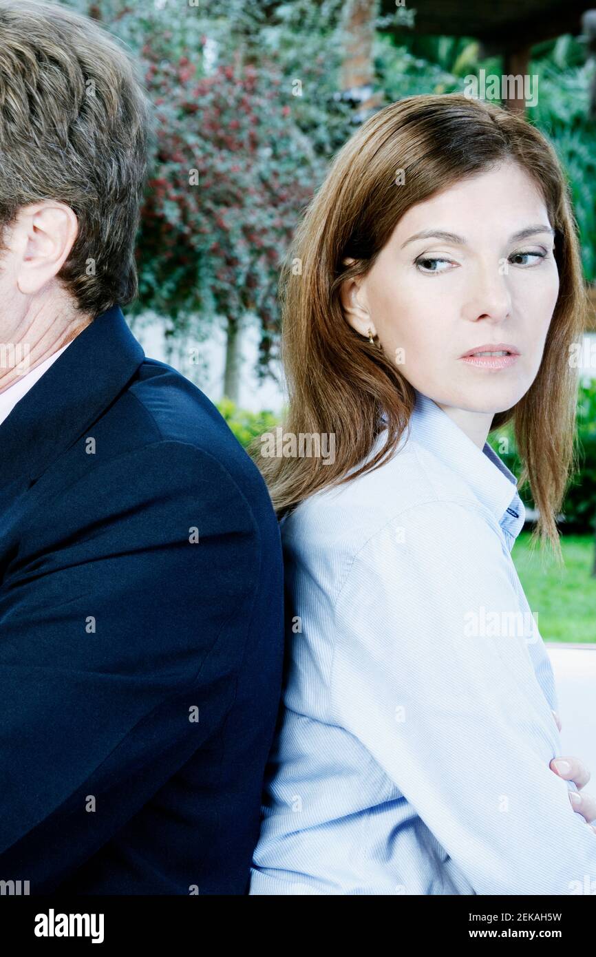 Geschäftsmann und eine Geschäftsfrau, die sich zurück an den Rücken lehnen Stockfoto