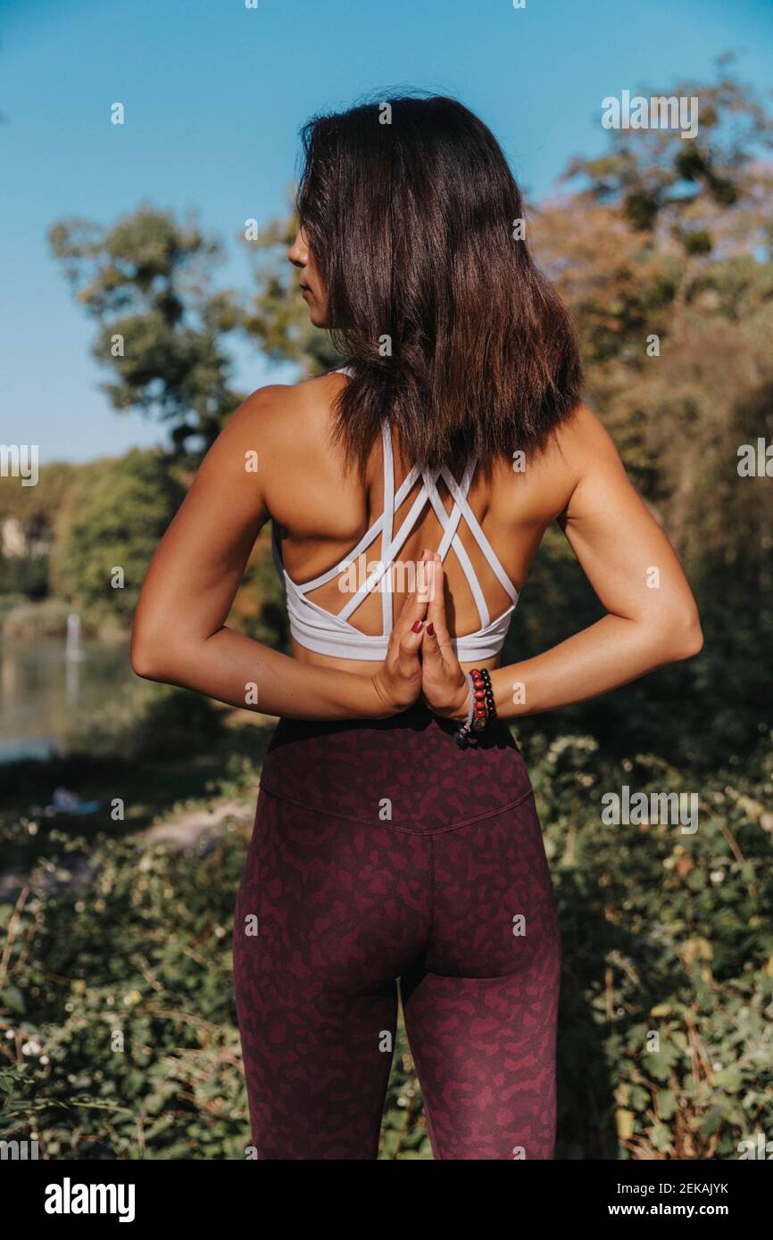 Reife Frau, die Yoga macht, während sie im öffentlichen Park steht Stockfoto