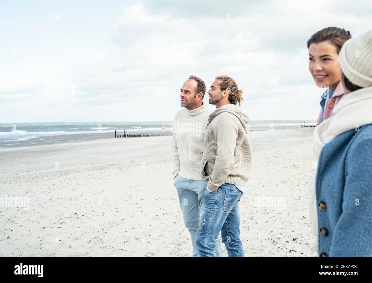 Gruppe von erwachsenen Freunden stehen und reden am Küstenstrand Stockfoto