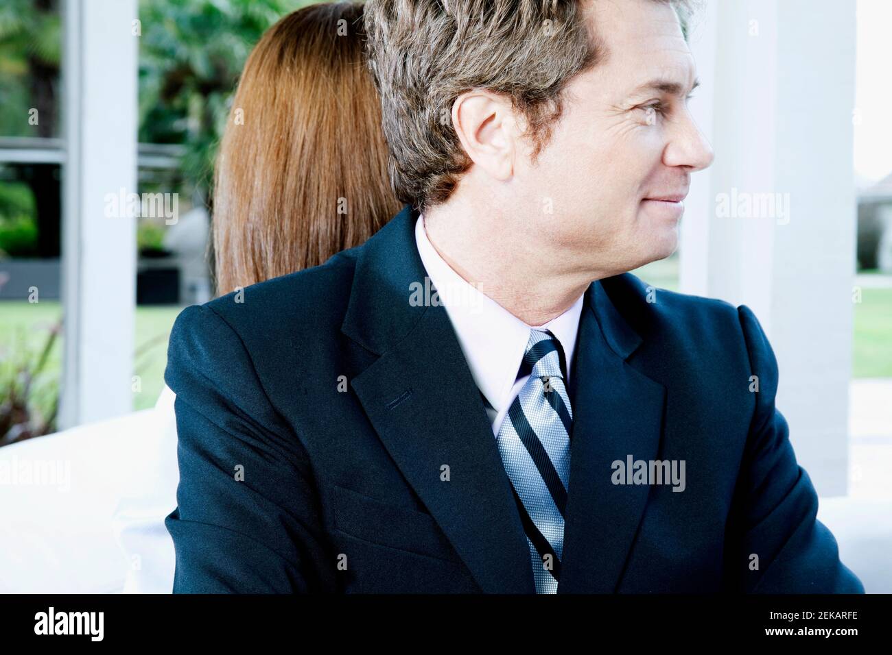 Geschäftsmann und eine Geschäftsfrau, die sich zurück an den Rücken lehnen Stockfoto