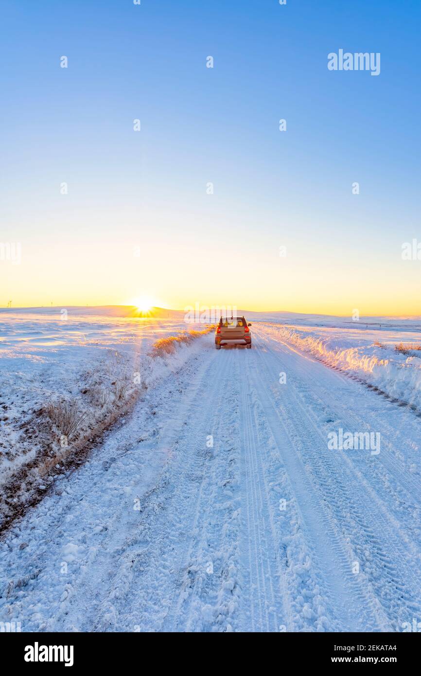 Großbritannien, Schottland, East Lothian, Wintersonnengang über Straße durch ländliche Landschaft Stockfoto