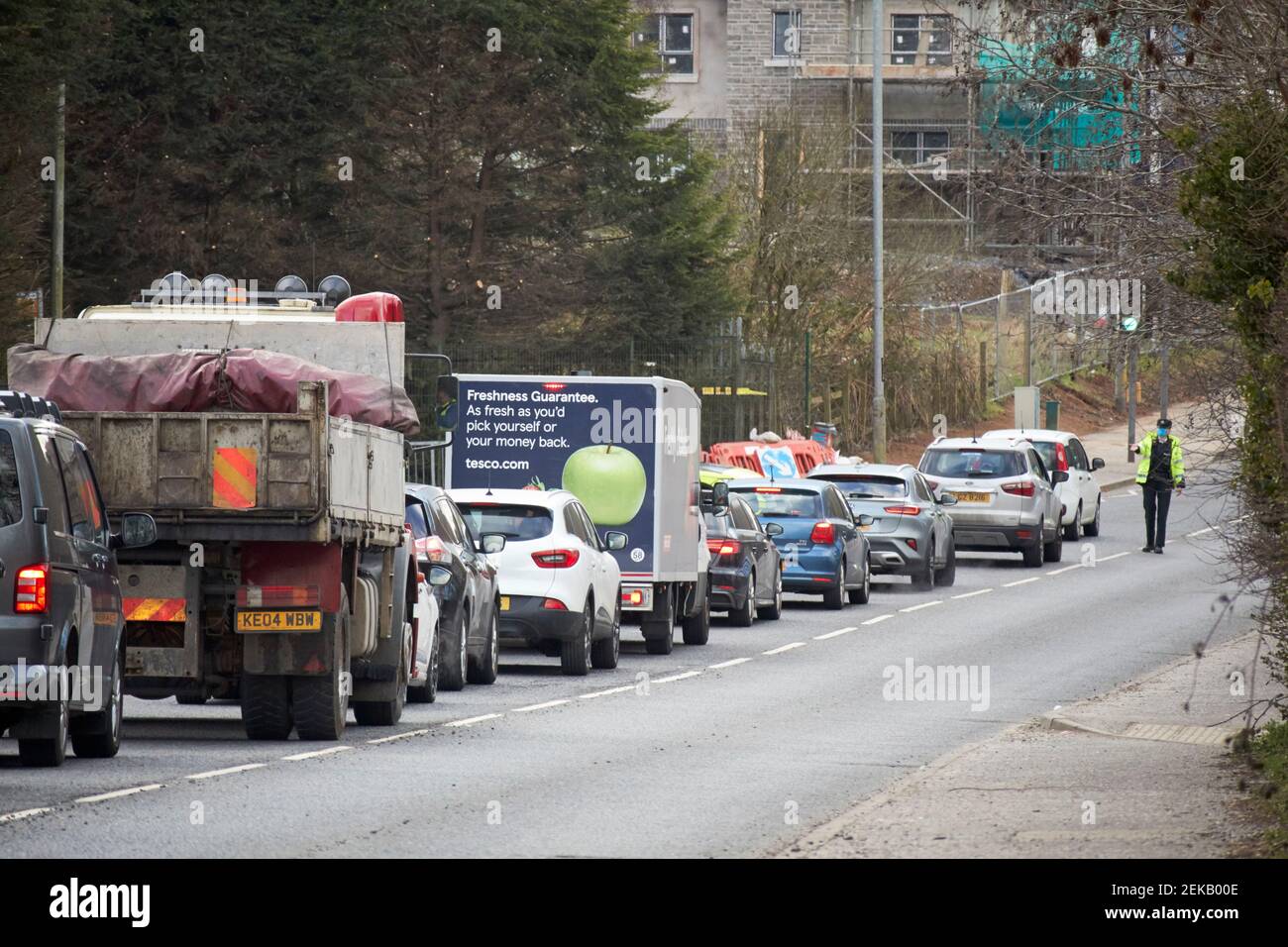 Schlange von Autos, die während des Coronavirus am psni Polizeikontrollpunkt warten Reisebeschränkungen Newtownabbey Nordirland Großbritannien Stockfoto