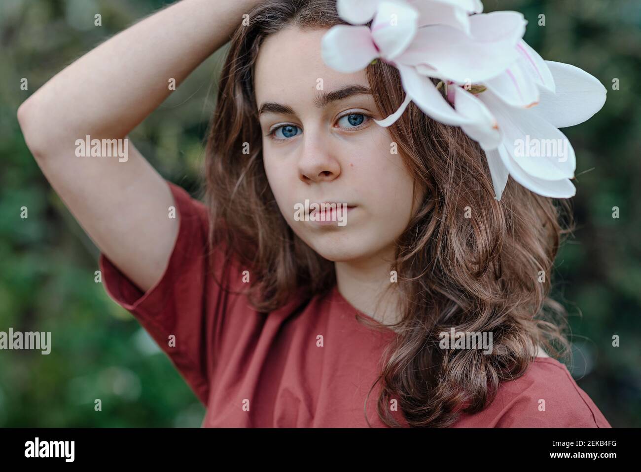 Mädchen mit blauen Augen trägt Magnolie Blume im Haar Stockfoto