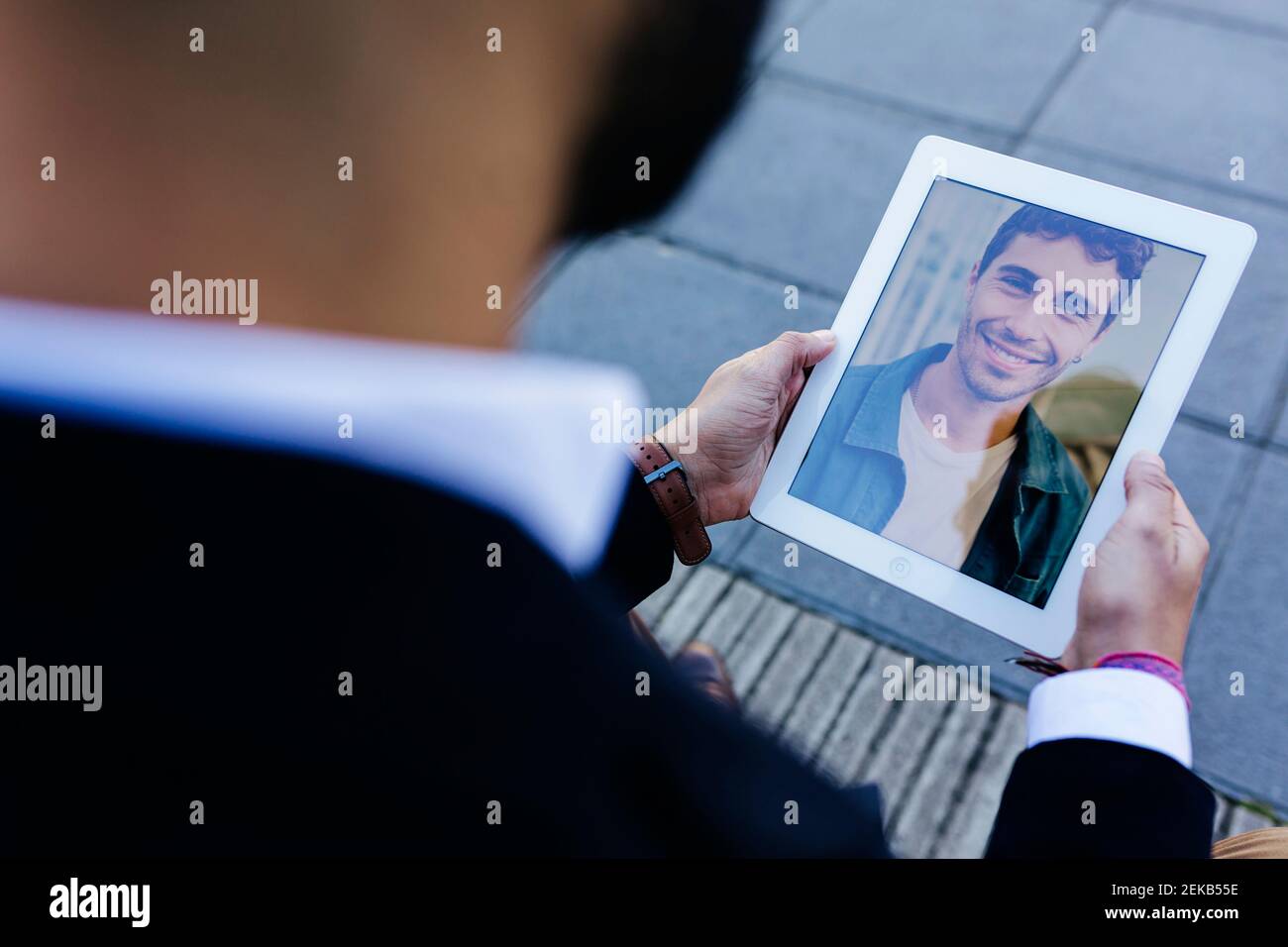 Geschäftsmann im Gespräch mit einem Freund über ein digitales Tablet, während er im Freien steht Stockfoto