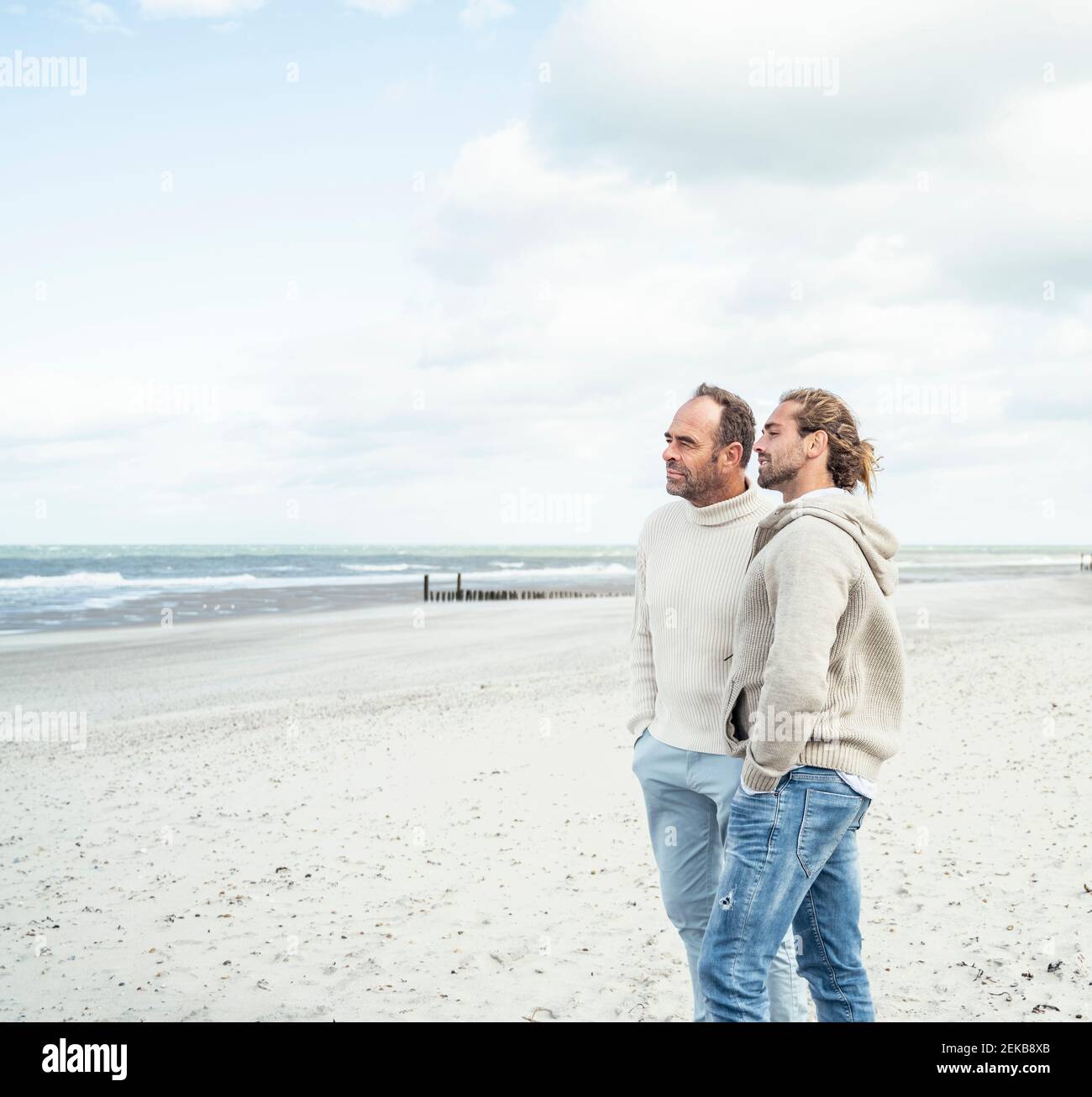 Zwei Männer stehen und reden am Küstenstrand Stockfoto
