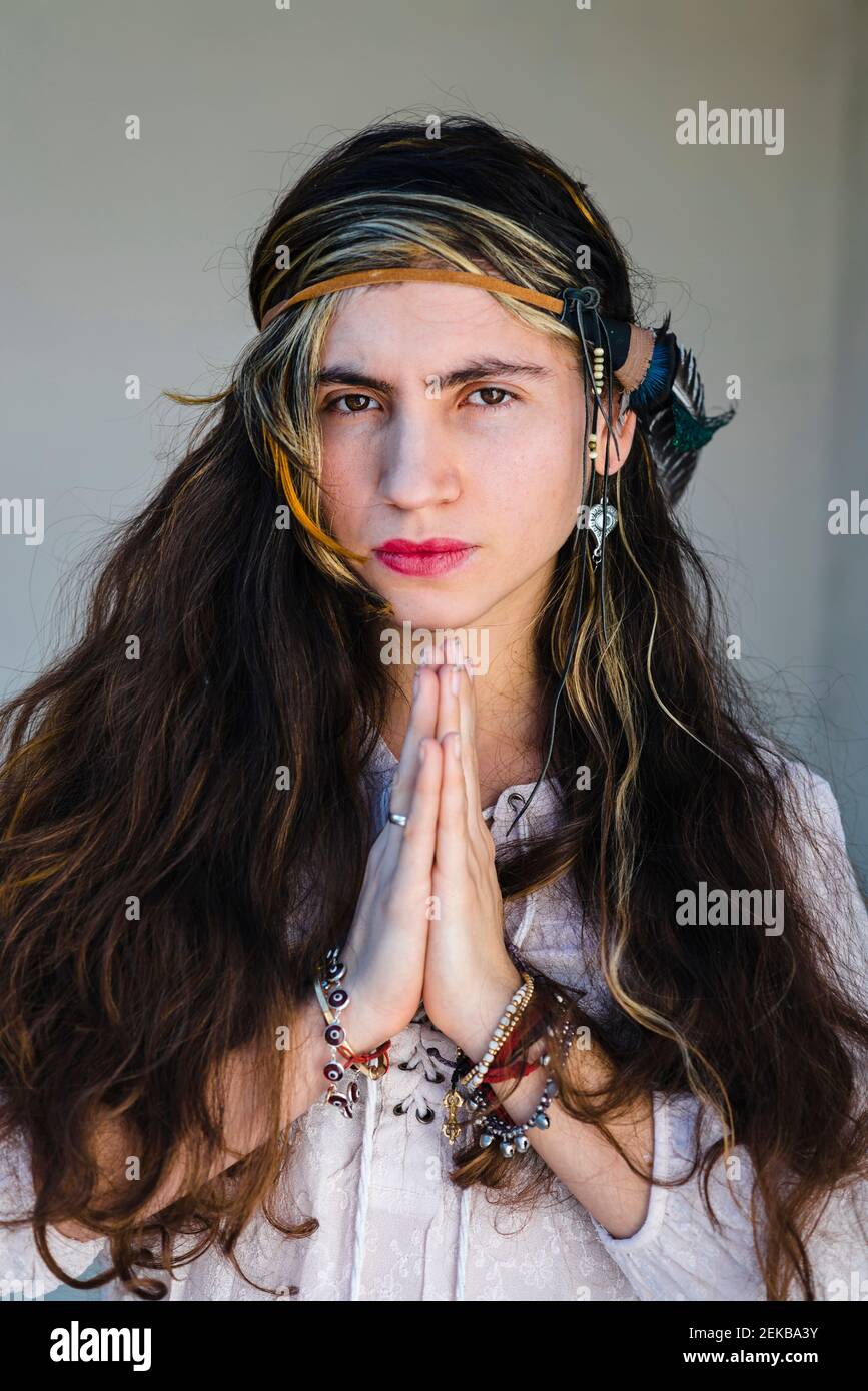 Hippie nachdenkliche junge Frau mit langen Haaren auf Stufen sitzend Stockfoto