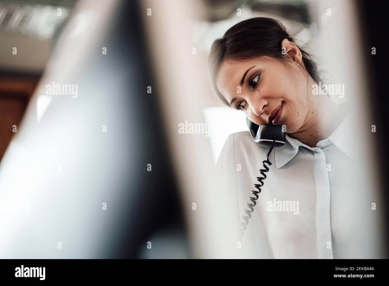 Weibliche Unternehmerin im Büro auf Festnetztelefon sprechen Stockfoto