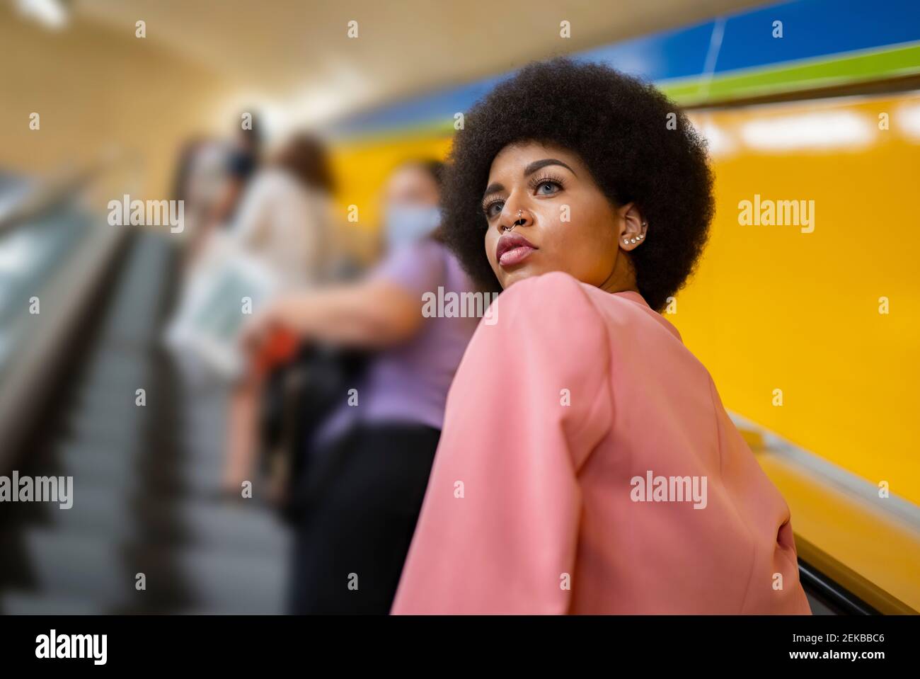 Weibliche Hipster auf der Rolltreppe an der U-Bahn-Station Stockfoto