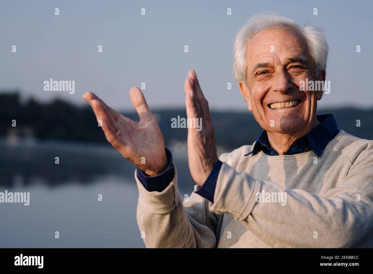 Fröhlicher Mann klatscht, während er draußen steht Stockfoto