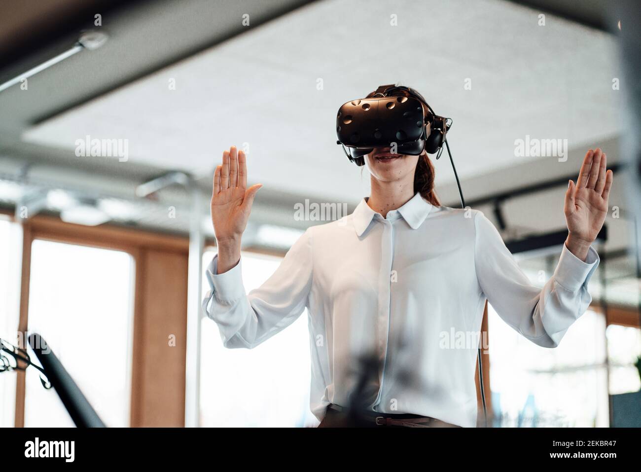 Weibliche Unternehmerin tun Stop-Geste, während mit Virtual-Reality-Simulator Im Büro Stockfoto