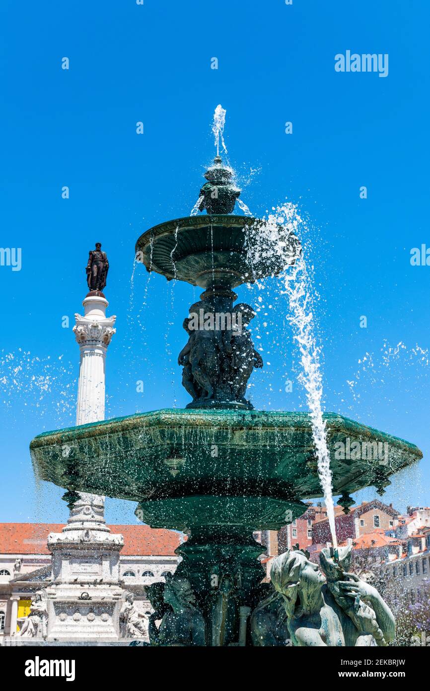 Portugal, Lissabon, Rossio, Brunnen auf Praca Dom Pedro IV mit Pedro IV Säule im Hintergrund Stockfoto