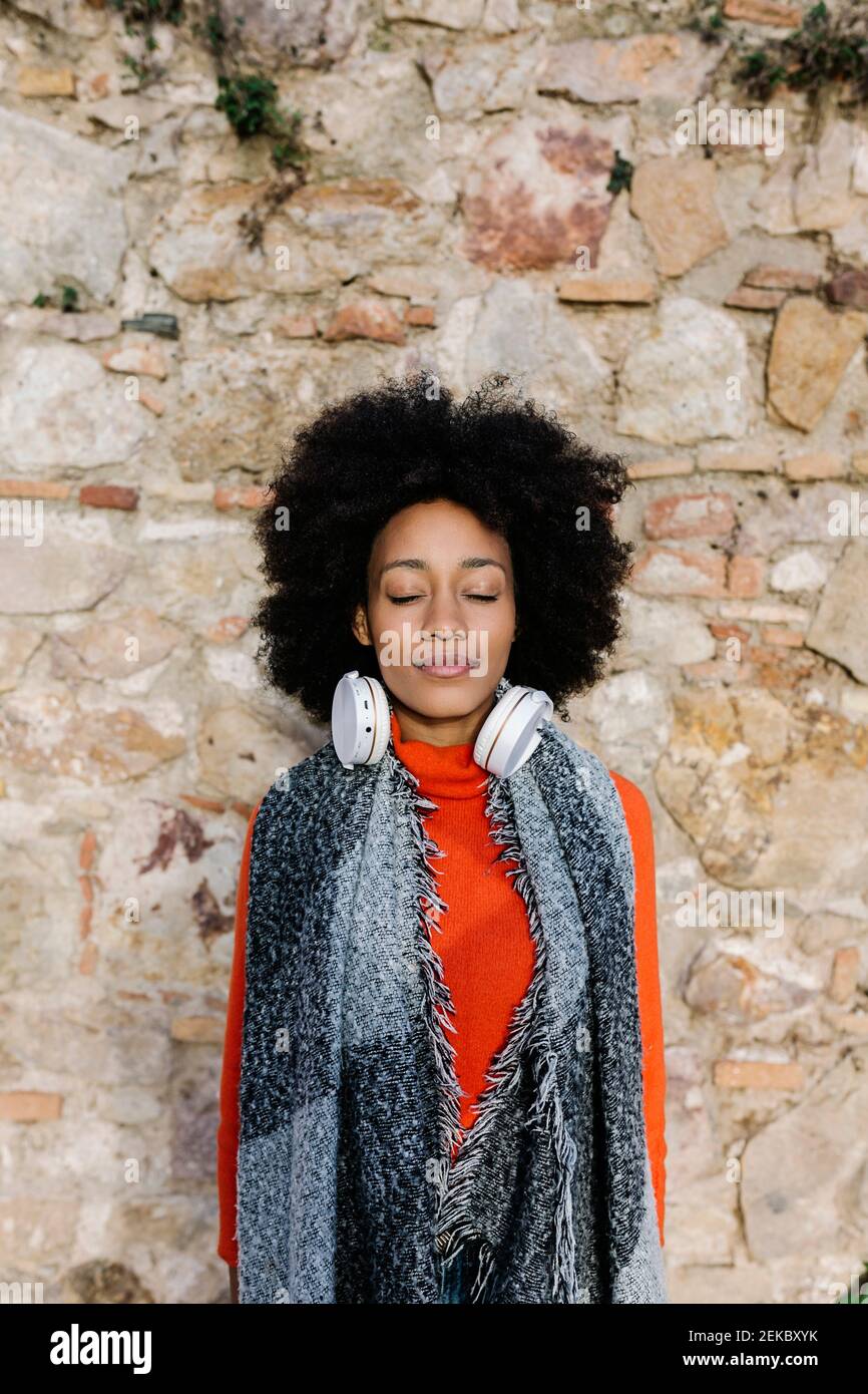Afro-Frau mit geschlossenen Augen gegen Steinmauer Stockfoto