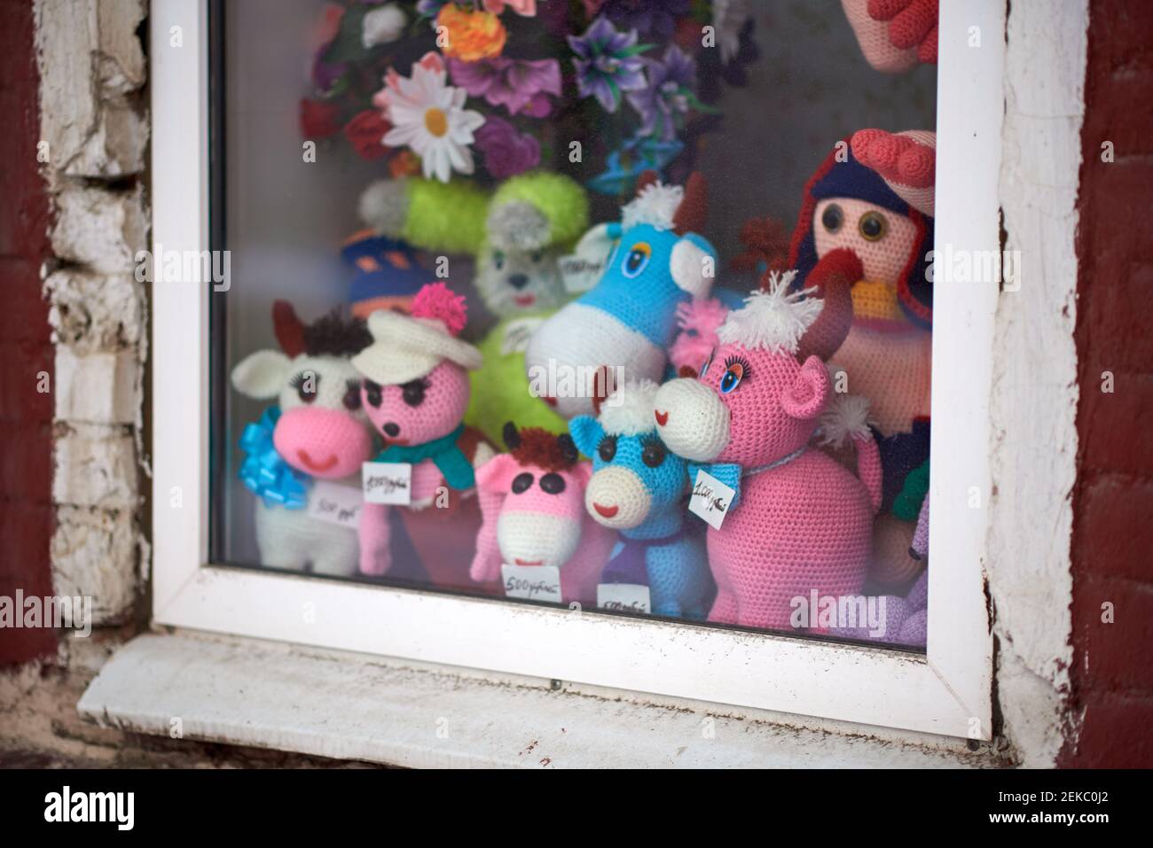 Ein Satz von mehrfarbigen Strickspielzeug zum Verkauf in einem Fenster angezeigt. Preisschilder in Russisch: 500 Rubel, 1000 Rubel Stockfoto