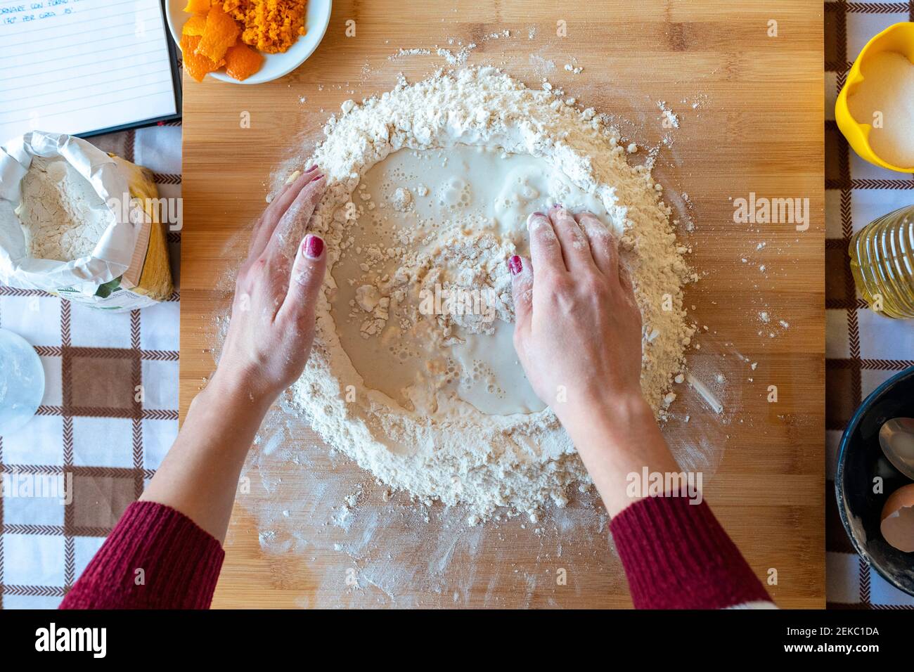 Frau, die Milch und Mehl auf dem Schneidebrett in der Küche mischte Stockfoto