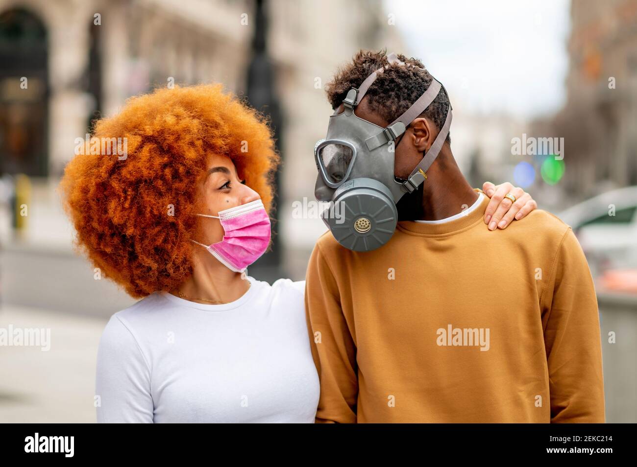 Paar trägt schützende Gesichtsmaske Blick auf einander, während Im Freien stehen Stockfoto