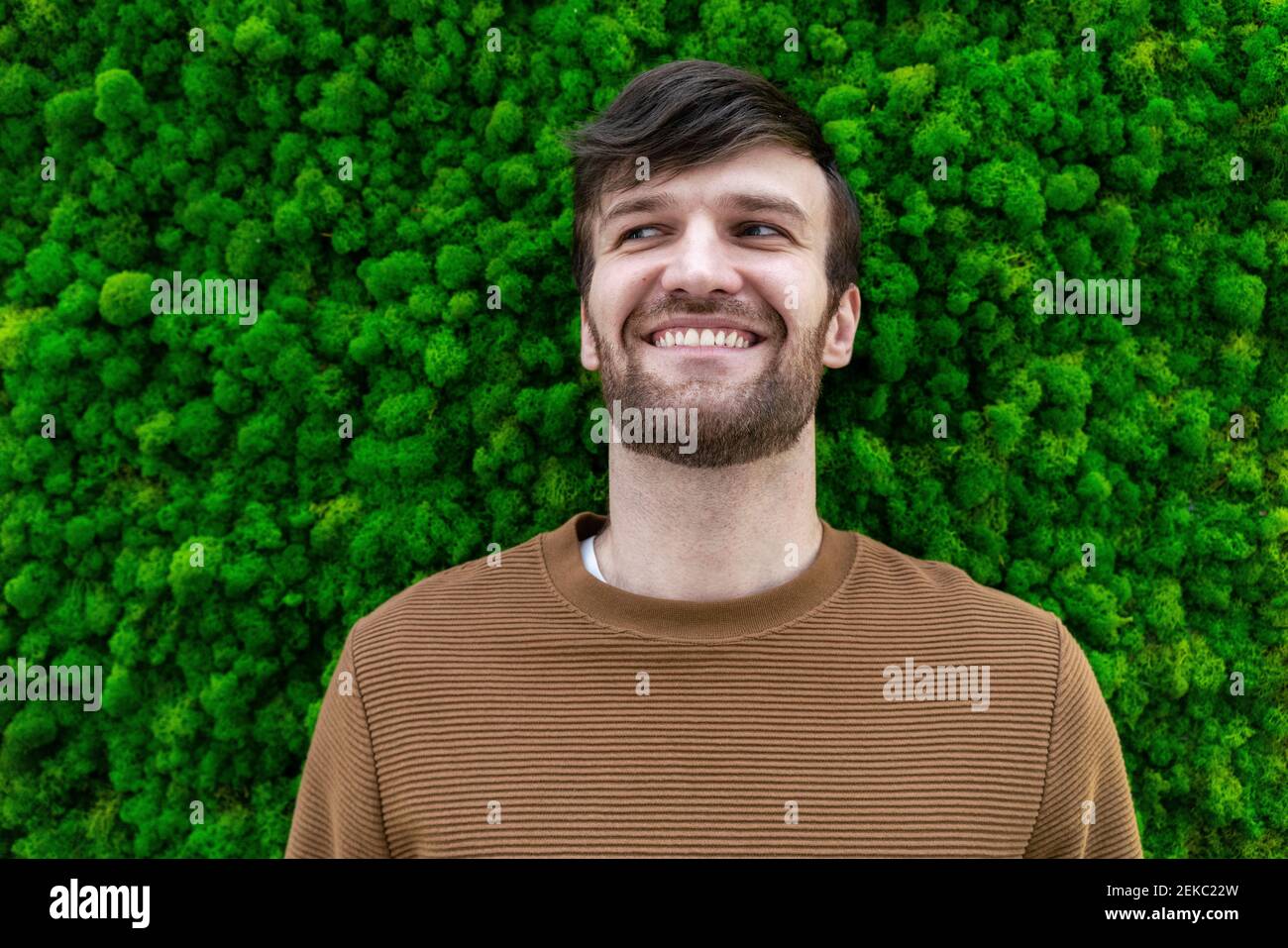 Glückliche männliche professionelle Blick weg vor grünem Hintergrund Stockfoto