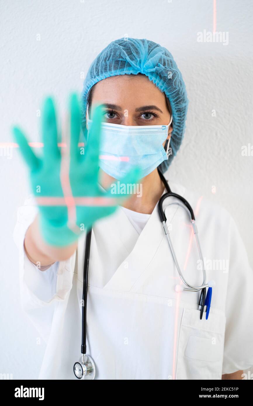 Ärztin tut Stop-Geste gegen Wand in der Klinik Stockfoto