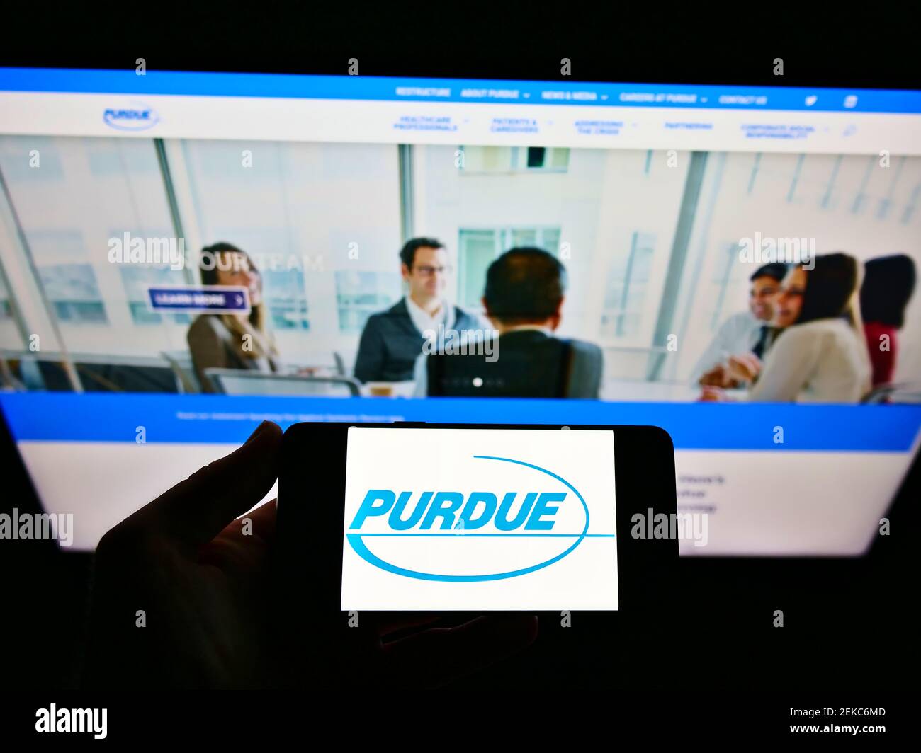 Person, die Smartphone mit Logo des US-Pharmaunternehmens Purdue Pharma L.P. auf dem Bildschirm vor der Website hält. Konzentrieren Sie sich auf die Telefonanzeige. Stockfoto