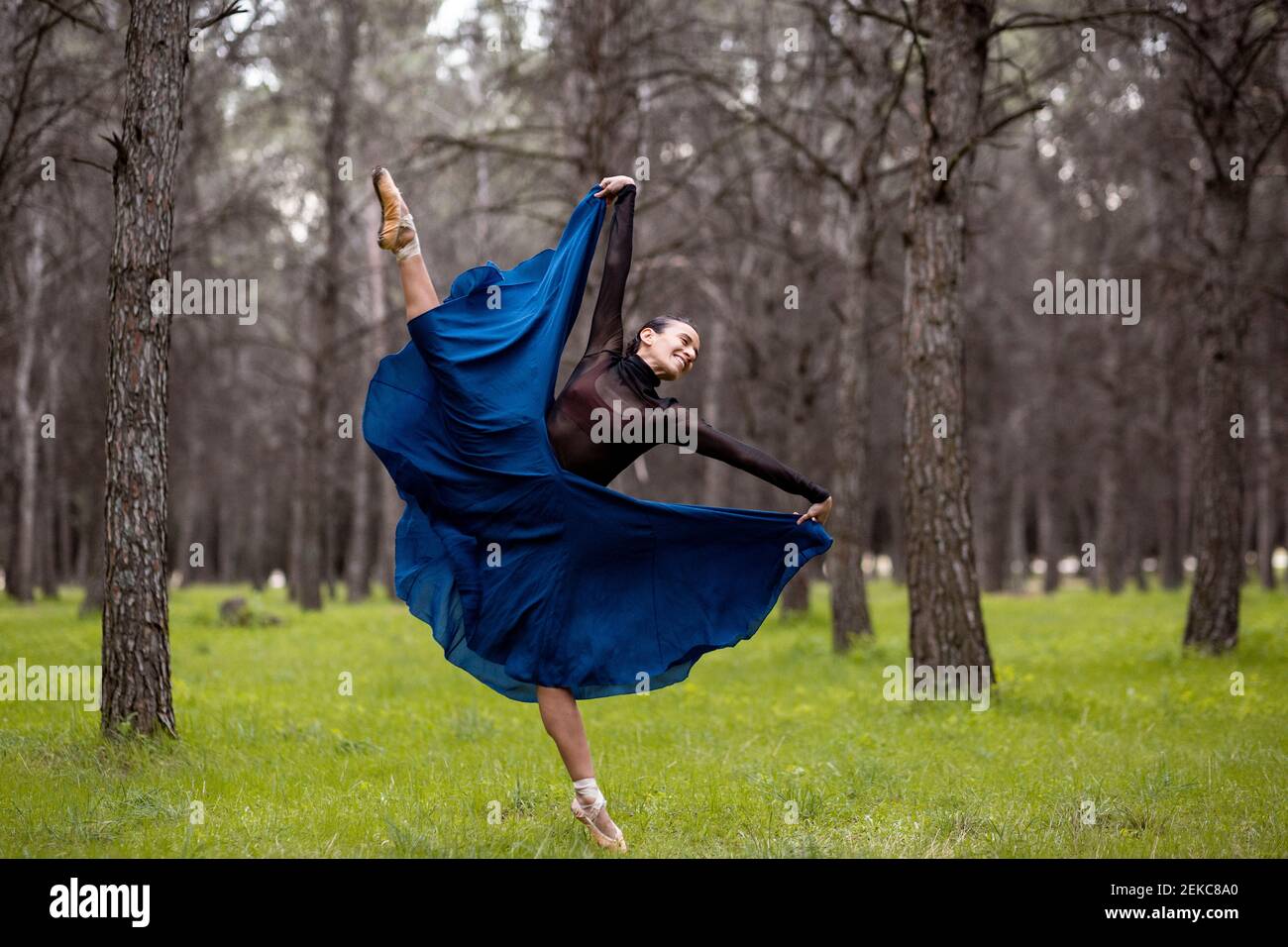 Leidenschaftliche Tänzerin lächelt beim Tanzen im Wald Stockfoto