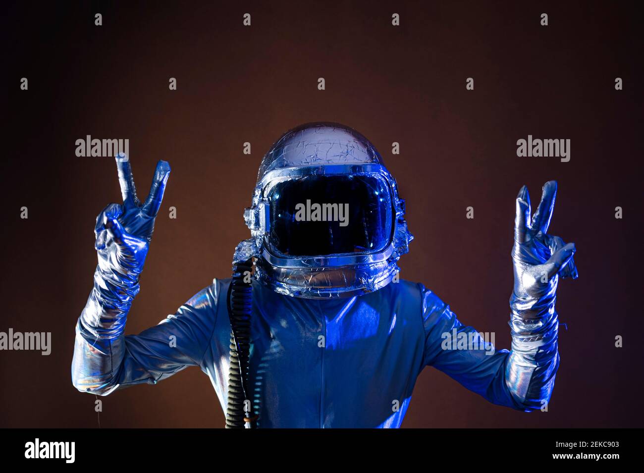 Männlicher Astronaut fotografiert vor farbigem Hintergrund aus der Kamera Stockfoto