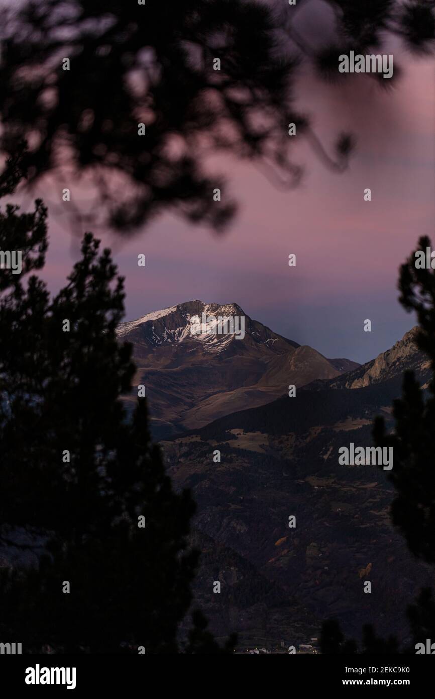 Spanien, Huesca, Berge spiegeln sich im Ibon De Plan See bei purpurem Sonnenuntergang Stockfoto