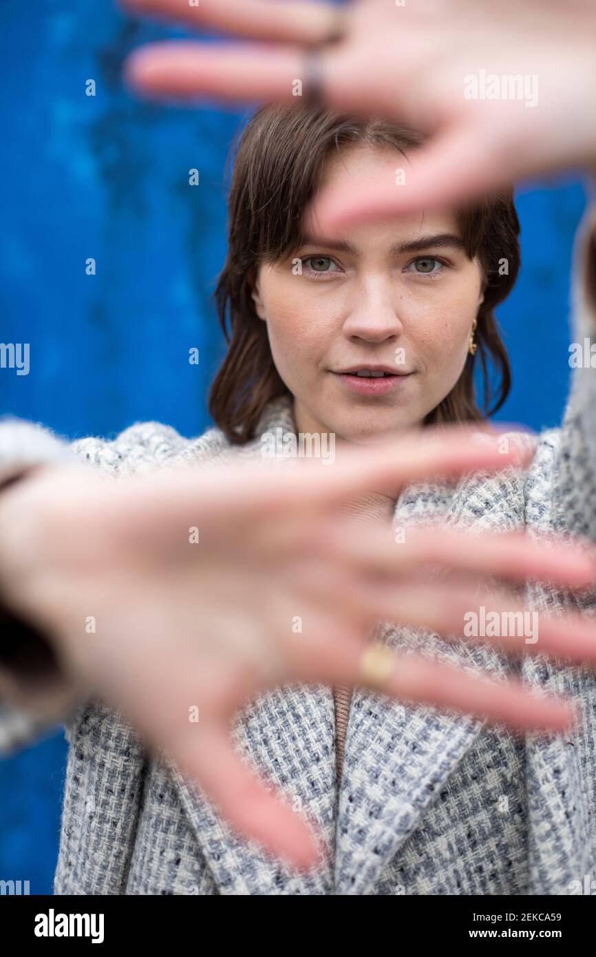 Schöne Frau mit grünen Augen mit Stop-Geste gegen blau Wand Stockfoto