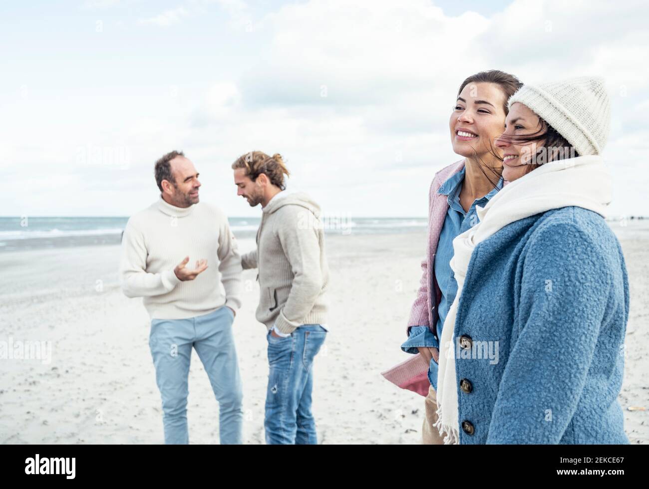 Gruppe von erwachsenen Freunden stehen und reden am Küstenstrand Stockfoto