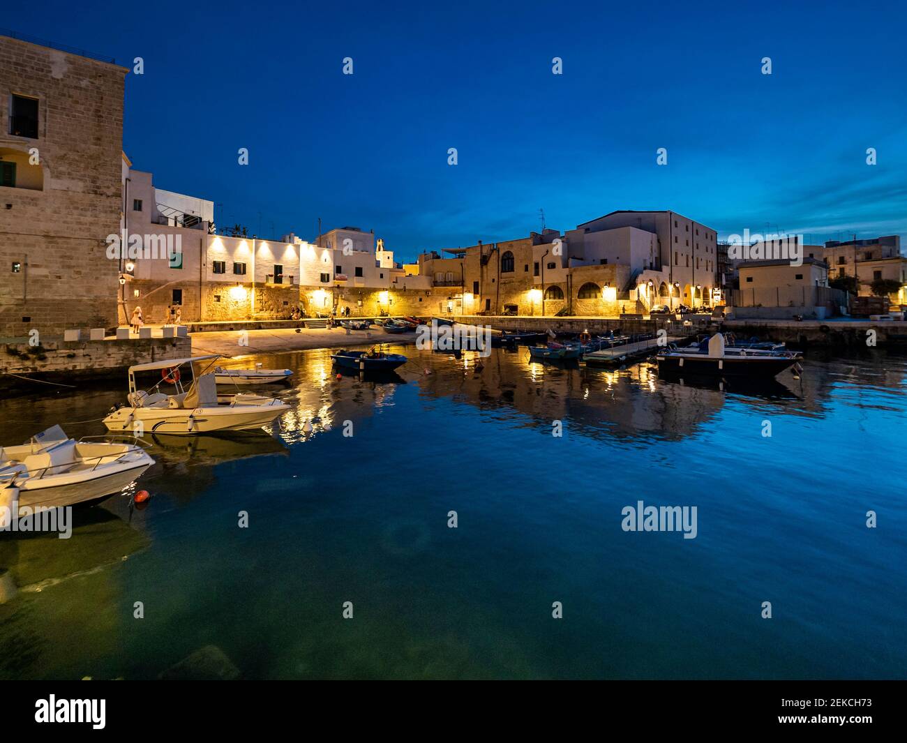 In der Abenddämmerung, Italien, liessen sich Seeschiffe im blauen Meer gegen Monopoli in Apulien festmachen Stockfoto