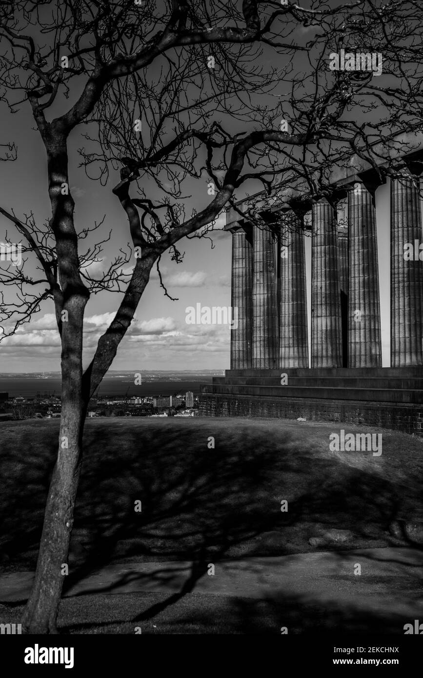 Leeres Nationaldenkmal auf Calton Hill, Edinburgh am sonnigen Tag des Hinweises am Himmel während der Sperre 2021. Aufgenommen in dramatischem Schwarz-Weiß. Stockfoto
