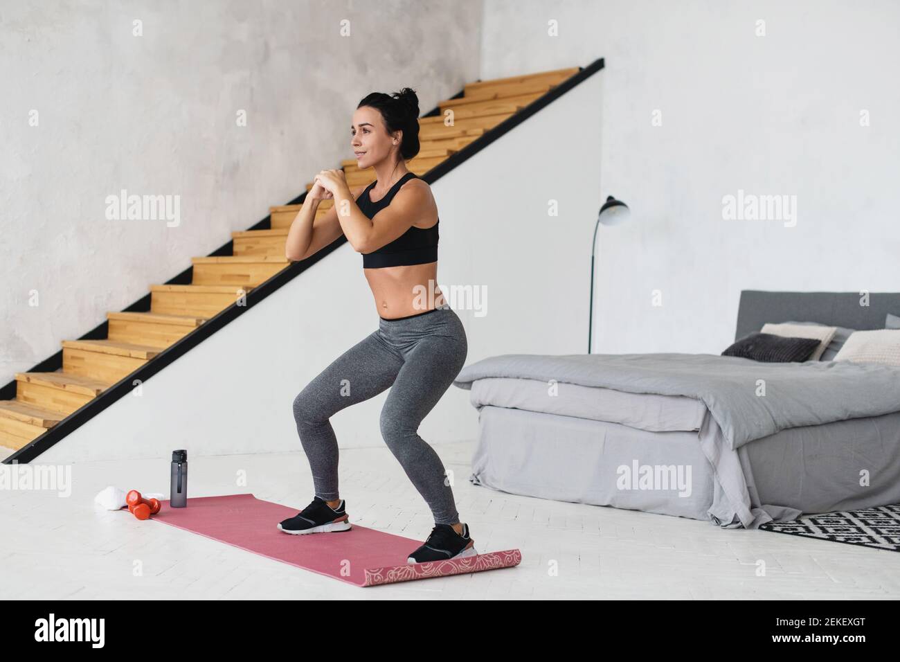 Junge schöne sportliche Frau tun hocken zu Hause. Stockfoto