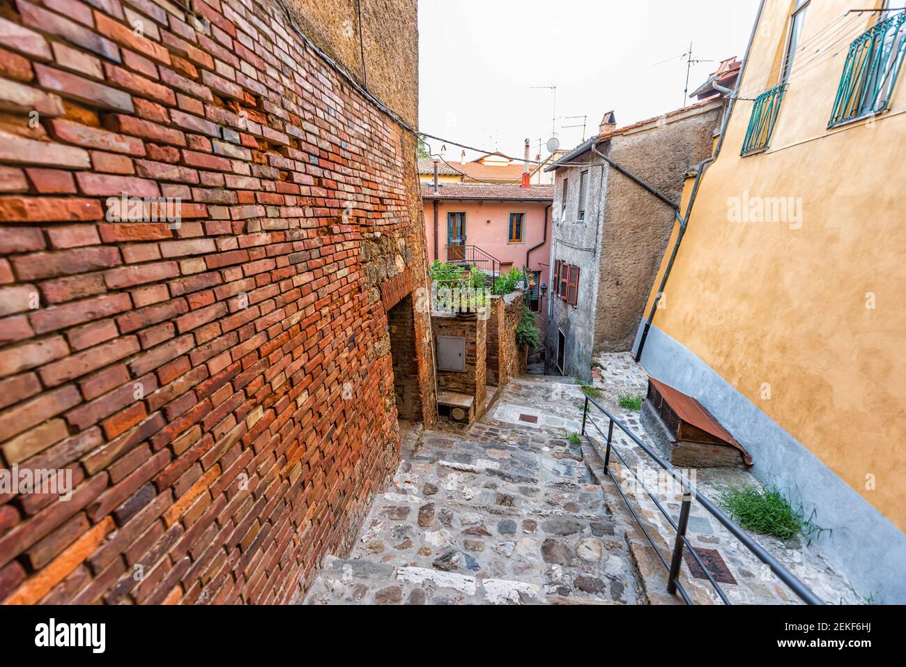 Chiusi, Italien Straße schmale leere Gasse Straße in kleinen historischen Dorf in der Toskana bunte Backsteinmauer von Häusern und Gartenpflanzen Stockfoto