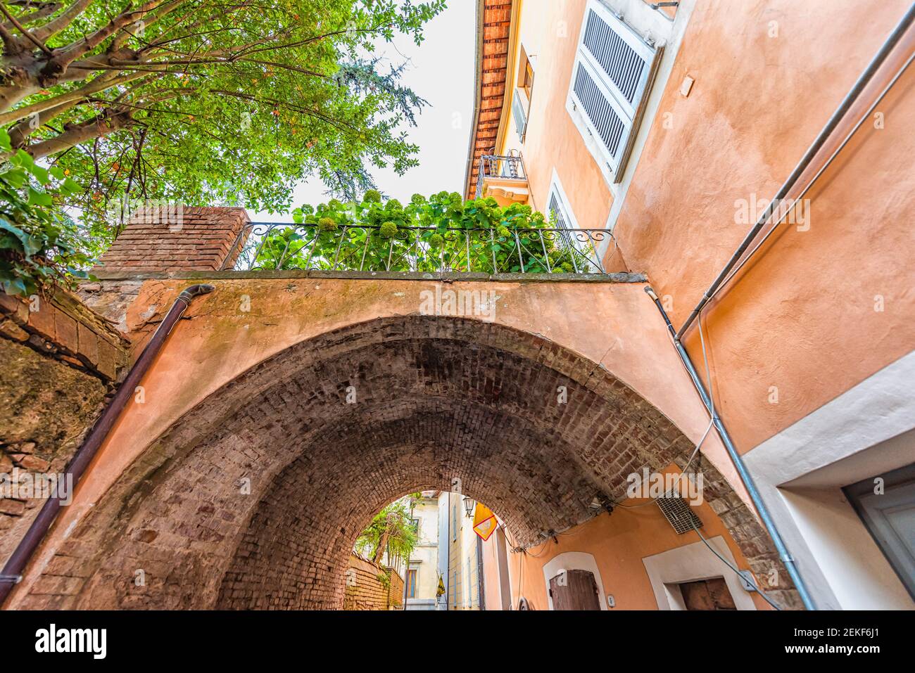 Chiusi, Italien Straße in kleinen historischen mittelalterlichen Dorf in der Toskana Sommer mit niemand orange bunte Wand und Bogen Gewölbe Durchgang Stockfoto
