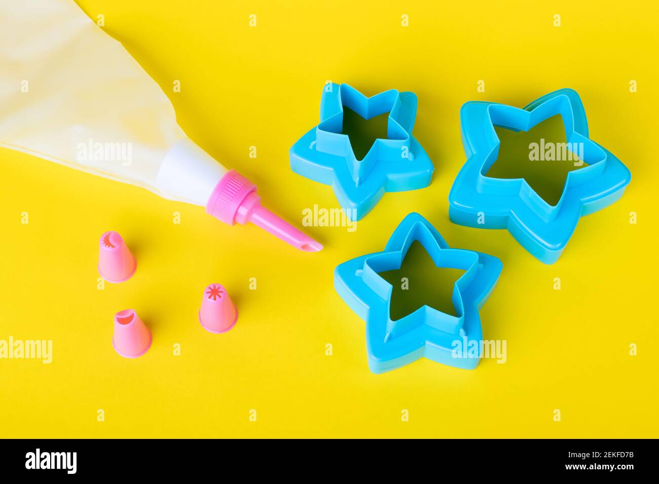 Sternförmige Ausstechformen. Kuchendekorationswerkzeuge, Tüte mit Düsen auf gelbem Hintergrund zum Dekorieren von Kuchen. Süßwaren Kochen Konzept w Stockfoto