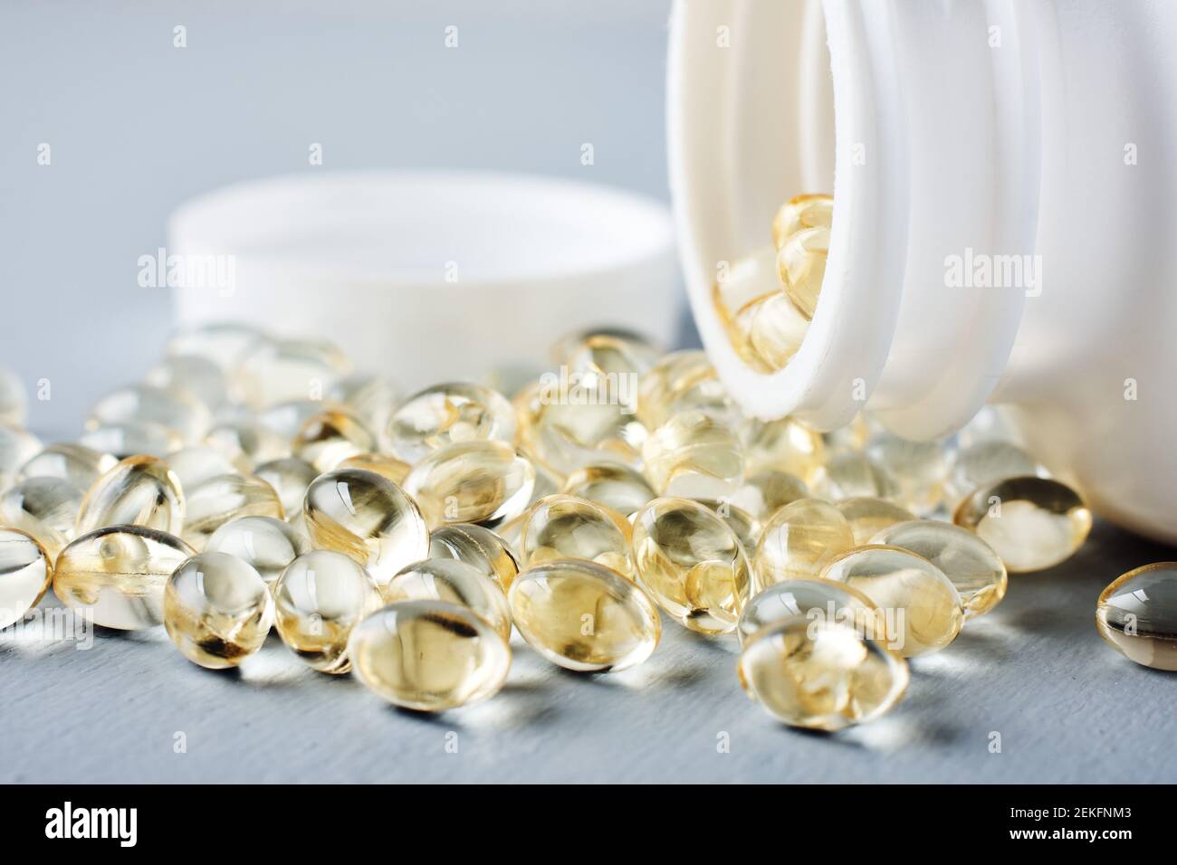 Gelbe Kapseln von Vitamin D auf einer grauen Oberfläche. Stockfoto