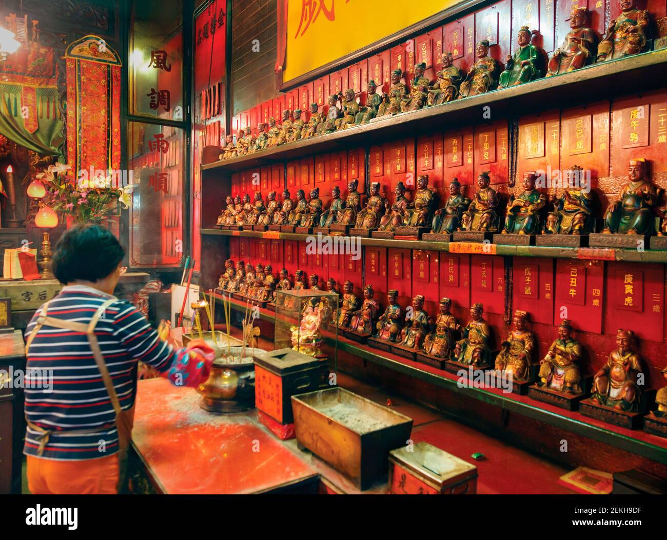 Hongkong, China. Frau vor Figuren im Tin Hau Tempel in Yau Ma Tei, Kowloon. Dieser traditionelle chinesische Tempel, wo Tin Hau, die Göttin von SE Stockfoto