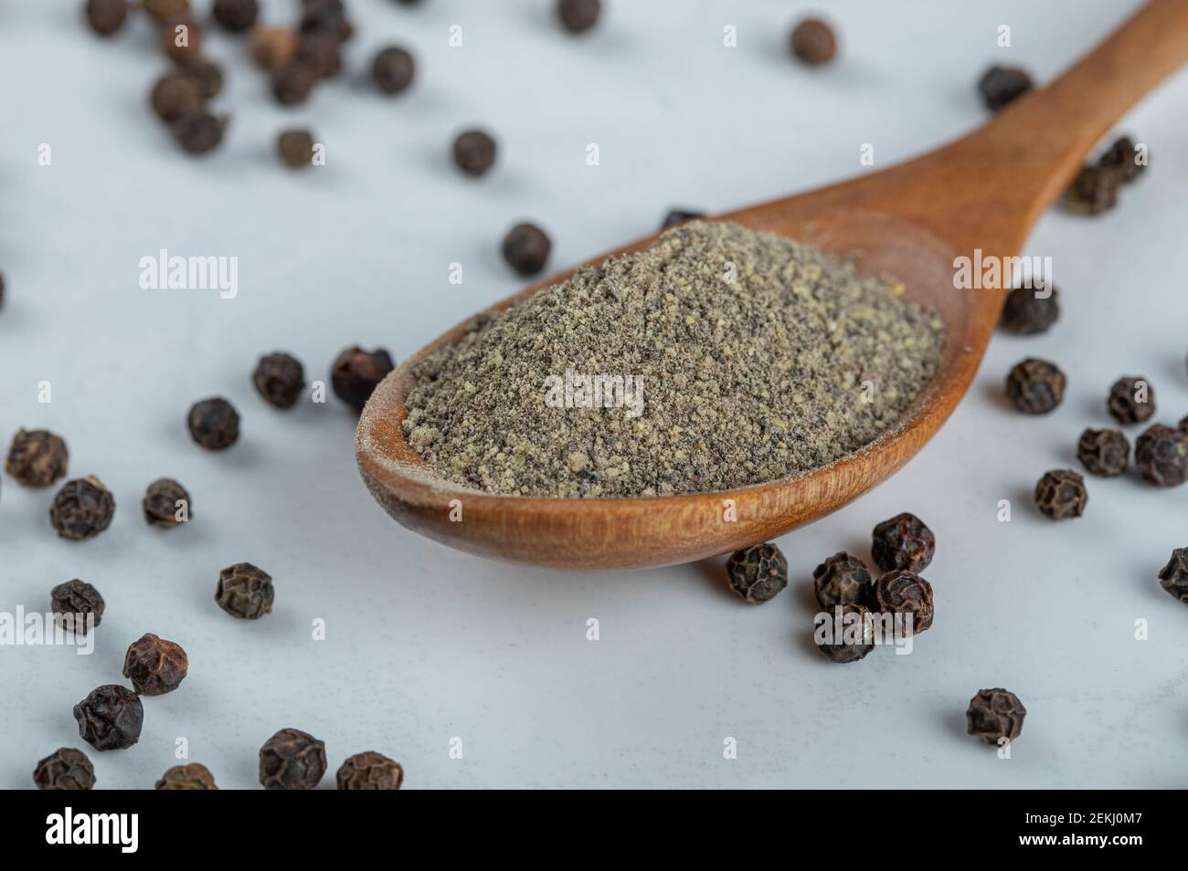 Ein Holzlöffel voll getrocknetem Pfefferpulver Stockfoto