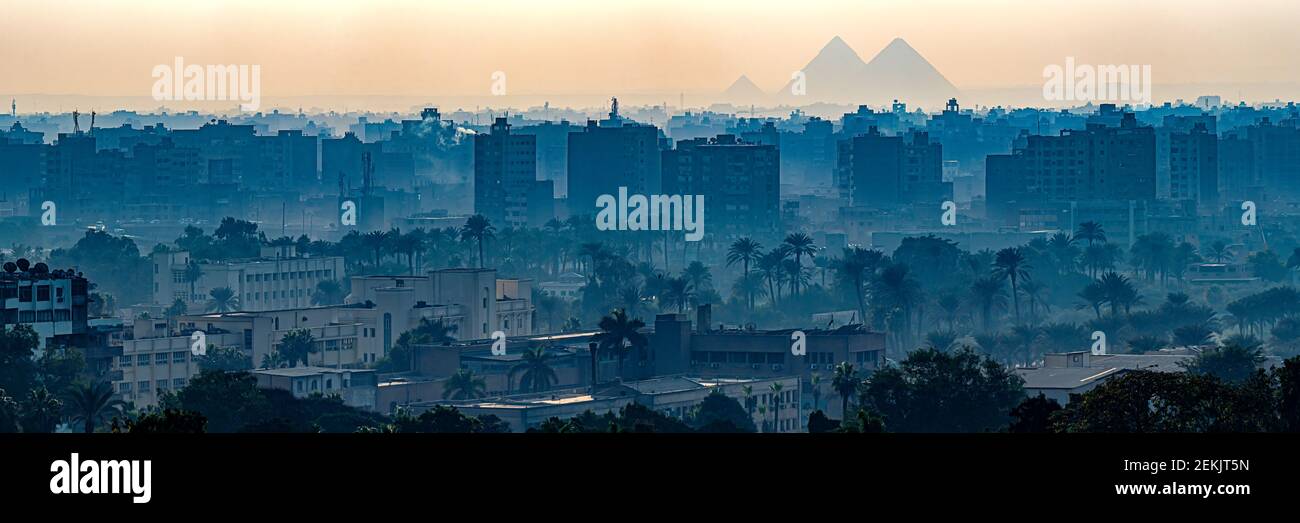 Neblige Stadtlandschaft von Kairo mit Gizeh Pyramiden in der Abenddämmerung, Kairo, Ägypten Stockfoto