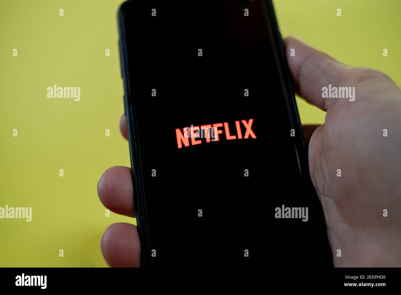 Man Hand Ansicht, während mit netflix App auf einem Smartphone, Video Streaming-Plattform Stockfoto