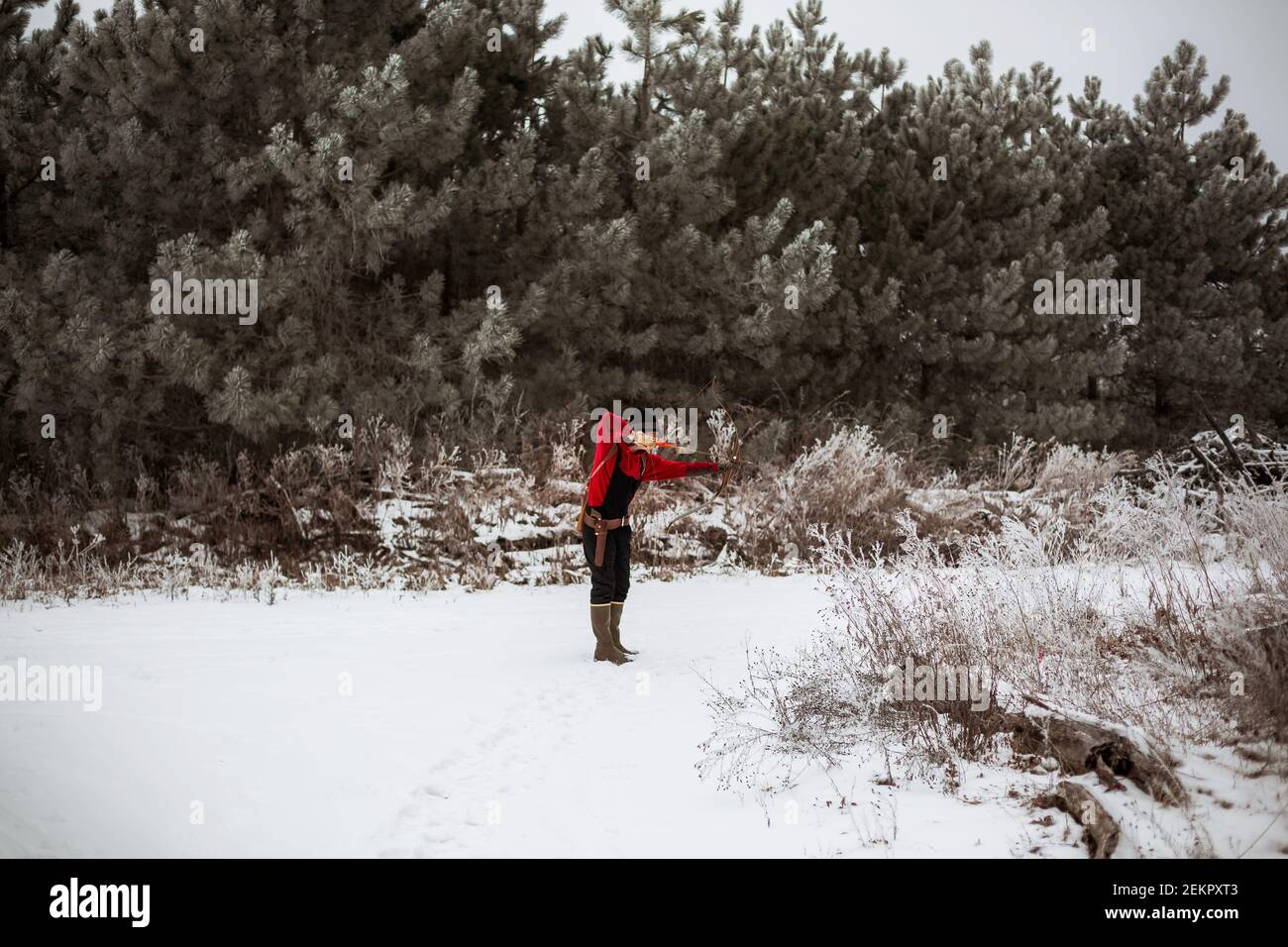 Teen junge schießen Bogen und Pfeil im winterlichen Wisconsin Feld Stockfoto