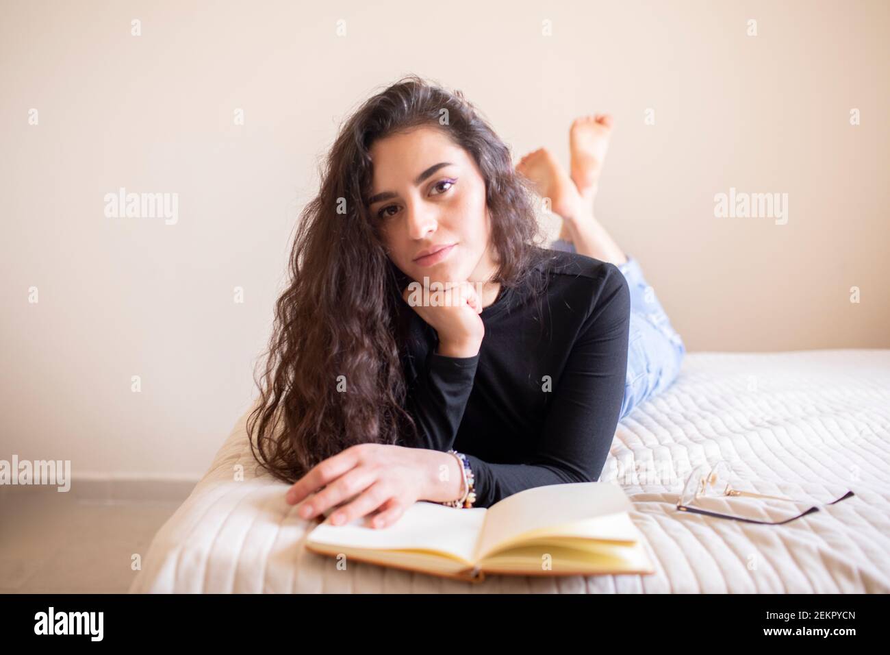 Junge Frau im Bett studieren Stockfoto