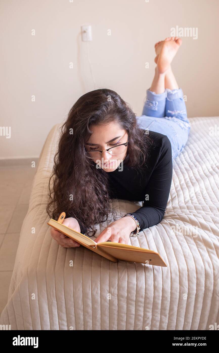 Junge Frau im Bett studieren Stockfoto