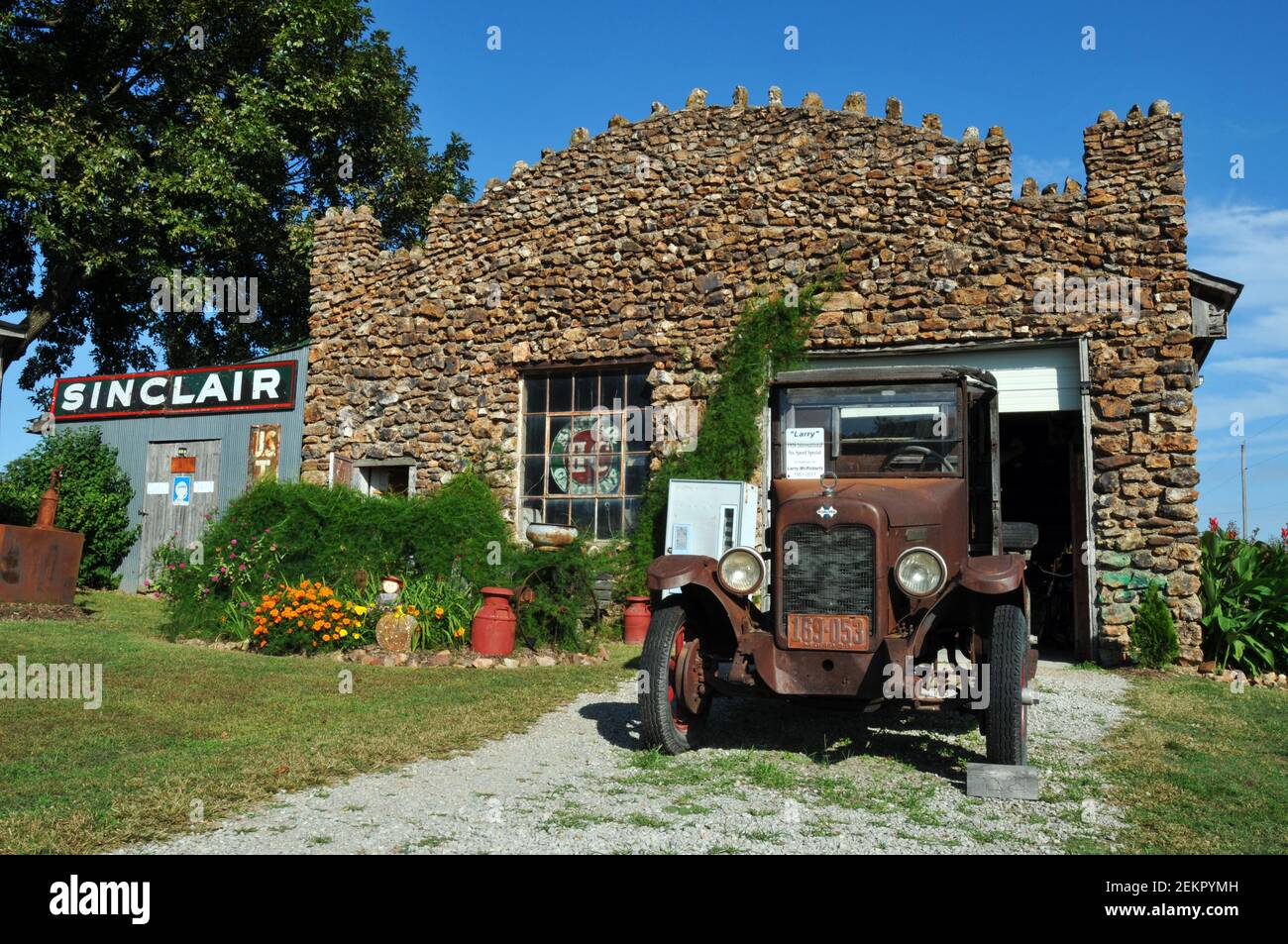 Ein antikes Fahrzeug parkt vor der 1926 gepflasterten Garage an der Gay Parita Tankstelle, einem Wahrzeichen der Route 66 und Attraktion am Straßenrand. Stockfoto Ein antikes Fahrzeug parkt vor der 1926 gepflasterten Garage an der Gay Parita Tankstelle, einem Wahrzeichen der Route 66 und Attraktion am Straßenrand. Stockfoto